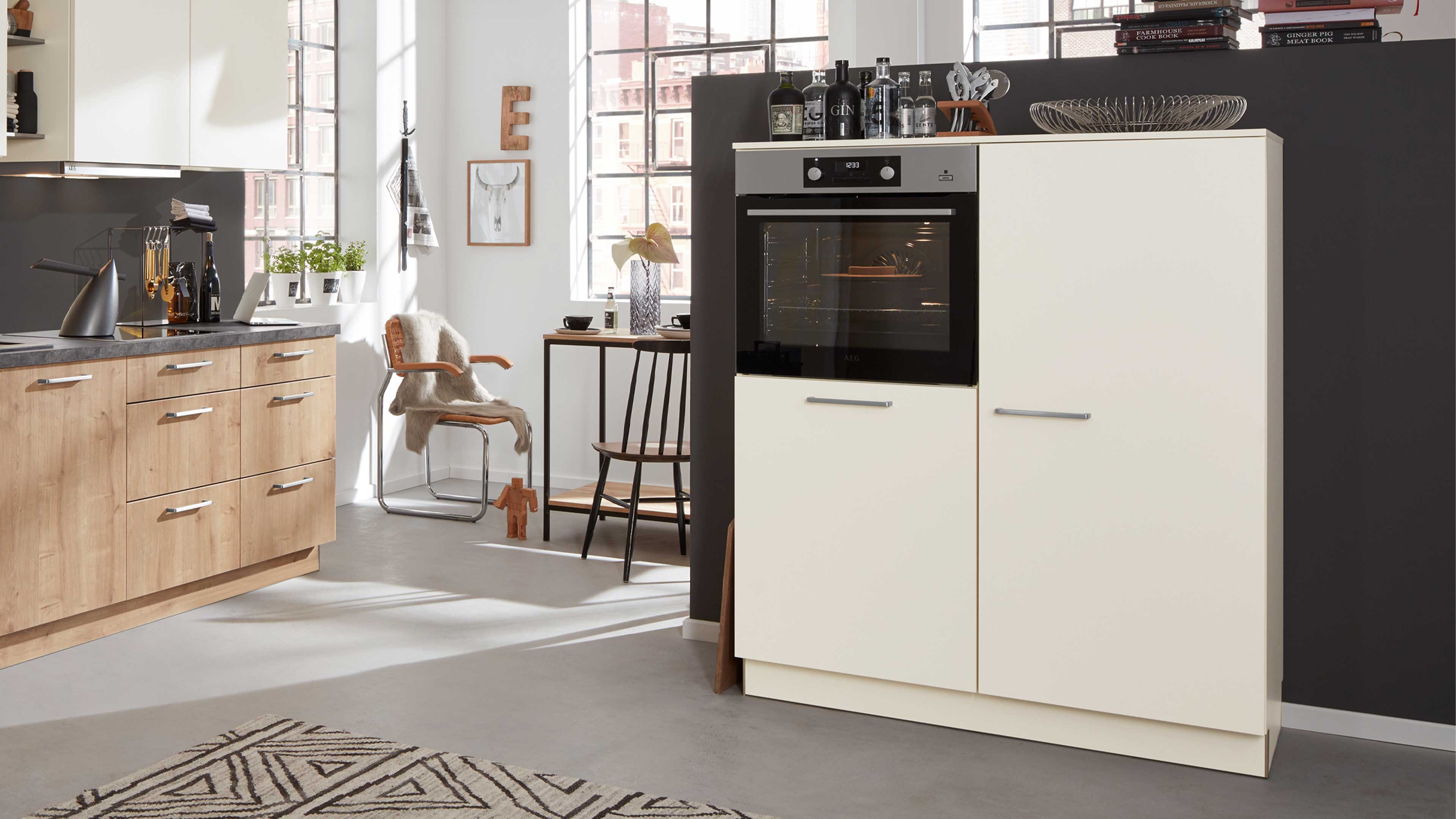 Hochschrank mit eingebautem Backofen, zwei cremefarbene Fronttüren mit silbernen Griffen und sichtbarer schwarzer Ofentür.