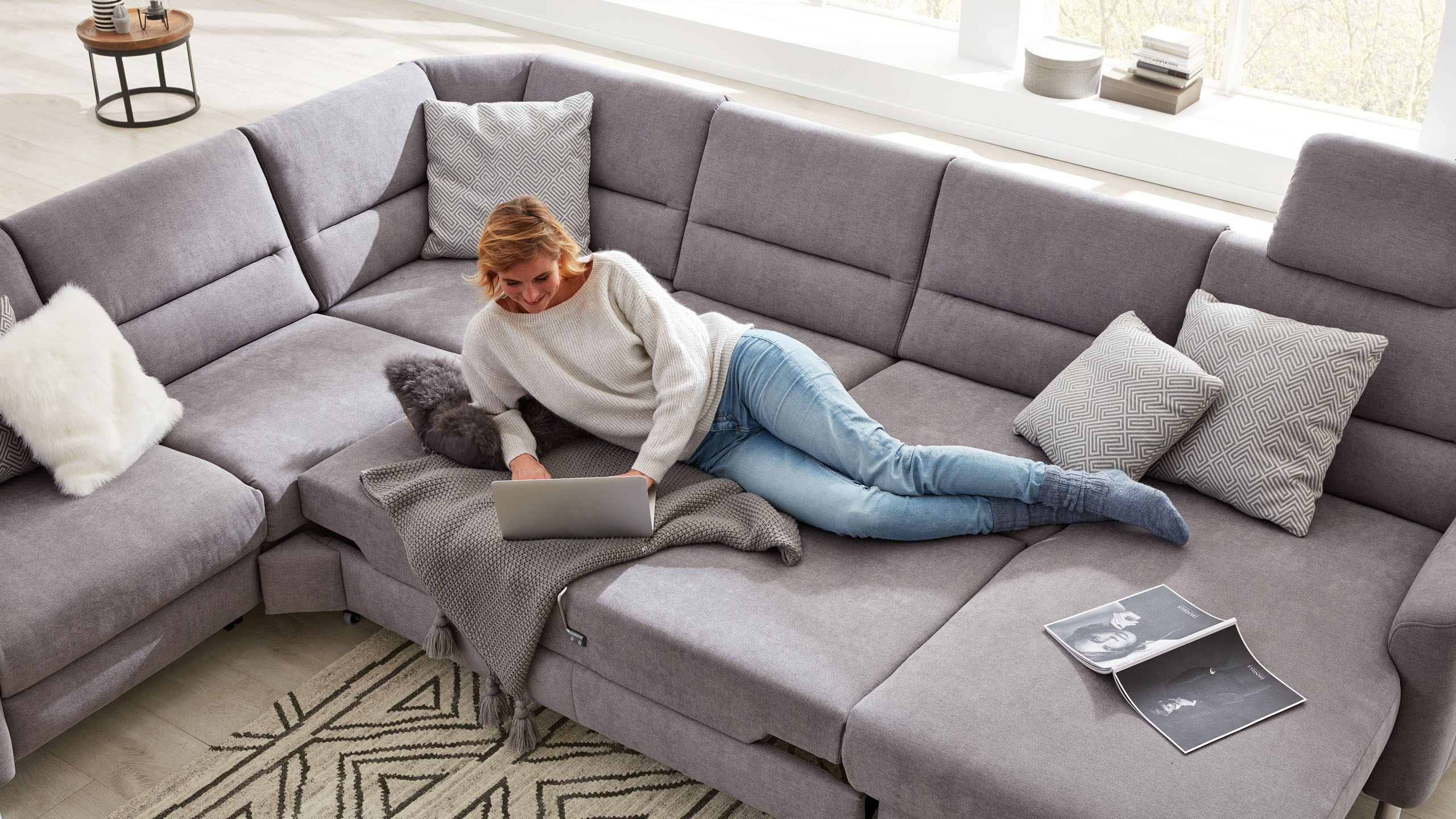 Frau liegt auf Interliving Sofa der Serie 4305 in grau